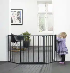 Baba biztonsági rács fekete színben, ami fel van fúrva a falra és egy kisgyermek kapaszkodik a babarácsba.